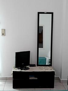 a room with a tv and a mirror at Sitia Holidays 1 in Sitia