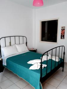 a bedroom with a bed with a green comforter at Sitia Holidays 1 in Sitia