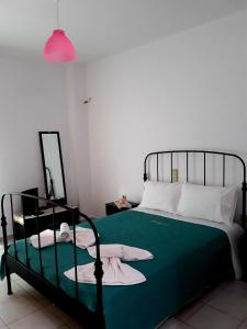 錫蒂亞的住宿－Sitia Holidays 1，一间卧室配有一张带绿床单和粉红色灯的床。