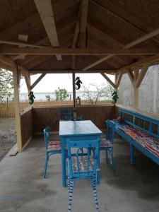 a blue table and chairs and a bench on a porch at Casa Batranului Pescar - Old Fisherman's House in Jurilovca