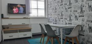 a dining room with a white table and chairs at Apartament Twoja Przystań in Giżycko