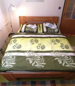 a bed with a green and white comforter at Apartmán v Jihlava City in Jihlava