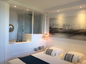 ein Schlafzimmer mit zwei Betten und einem Gemälde an der Wand in der Unterkunft Le Petit Vue Mer in La Croix-Valmer