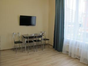 a dining room with a table and chairs and a television at Apartament Shkiperskaia 9 in Adler