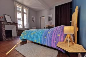 1 dormitorio con 1 cama con una manta colorida en Le bon'appart - 50m de la cathédrale en Montauban