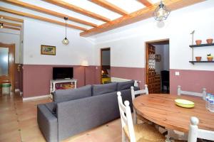 a living room with a couch and a wooden table at Finca Soñada - Nudist Resort in Gayanes