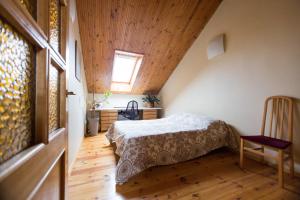 een slaapkamer met een bed en een houten plafond bij Apartment Vokiečių in Vilnius
