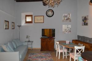 uma sala de estar com um sofá, uma mesa e uma televisão em Appartamento in Centro em Spoleto