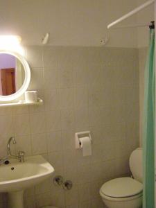 a bathroom with a toilet and a sink and a mirror at Hotel Tsagarada in Tsagarada