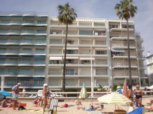 people on the beach in front of a hotel at Guillaumont Apartment in Juan-les-Pins