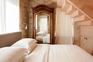 ein Schlafzimmer mit einem Bett und einem großen Spiegel in der Unterkunft Thomais 2-Villa Stone Estate with Pool & Sea Views in Agia Pelagia