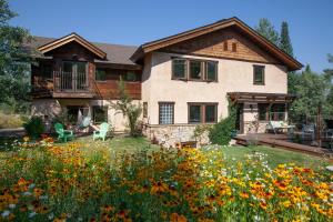 a house with a yard full of flowers at Chalet Val d'Isere in Steamboat Springs