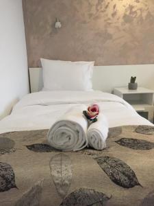 a bed with a blanket and a towel on it at Top Style Villa in Bragadiru