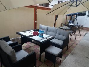 a patio with a table and chairs and an umbrella at Vila Massimo in Eforie Nord