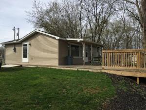 uma pequena casa com um alpendre e um deque em Martin's River Cabin em Dresden