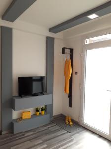 salon z telewizorem i przesuwnymi drzwiami w obiekcie Belvárosi apartman w mieście Szigetvár