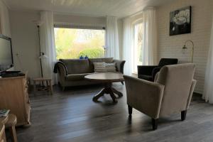 a living room with a couch and a table and chairs at Erve Eshuus Daarle in Daarle