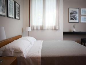 una camera con un letto bianco e una finestra di Bed And Breakfast 22 Garibaldi Home a Riccione