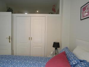 um quarto com uma cama e um armário branco em Apartamento AGP Centro Histórico em Málaga