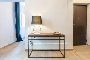 un tavolo con una lampada in una stanza di Syntagma Luxury Living One “LL1” Apartments ad Atene