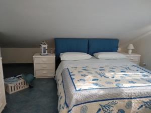- un lit avec une tête de lit bleue dans une chambre dans l'établissement Mansarda Camelie via dei Normanni, 45, à Campofelice di Roccella