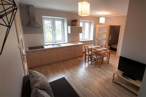 eine Küche und ein Esszimmer mit einem Tisch und einem TV in der Unterkunft Winnica Sandomierska in Dwikozy