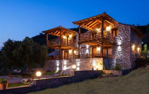 a large log house with lights on it at night at Amaryllis apartments in Toroni