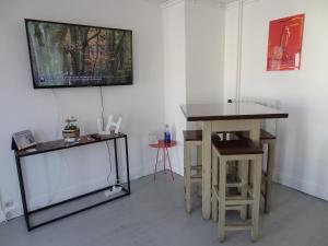 a room with a tv and a table and stool at LE MARITIME in Le Havre