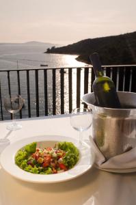 a plate of salad and a bottle of wine on a table at Hotel Sirena Hvar in Hvar