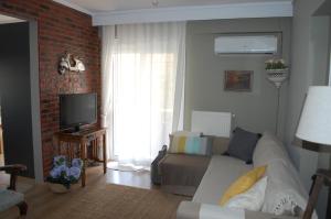 a living room with a couch and a brick wall at Cosy Home Boutique Apartment in Perea