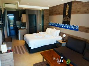 a hotel room with a bed and a couch at Katrin Luxury Studios in Nea Moudania