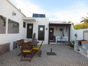 een patio met een tafel en stoelen en een huis bij Villa El Alcazar in Carvoeiro