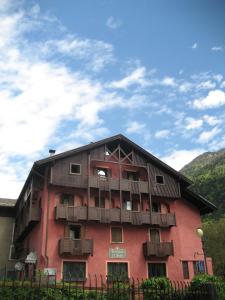 a large red building with balconies on it at Albergo Locanda Mezzosoldo in Mortaso