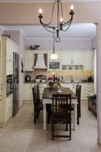 une cuisine avec une table et des chaises ainsi qu'un lustre dans l'établissement My Sweet Corner House, à Paleóchora