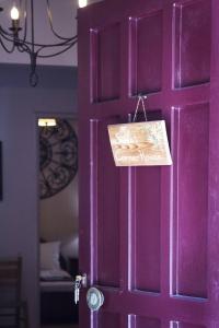 une porte violette avec un panneau sur elle dans l'établissement My Sweet Corner House, à Paleóchora