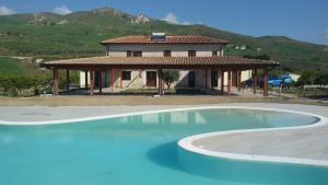a large swimming pool in front of a house at Tenuta Lanza Il Mulino in Acquaviva Platani