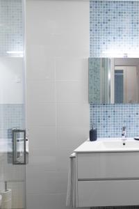 ein Bad mit einem Waschbecken und einem Spiegel in der Unterkunft East River - T4 junto ao Altice Forum - Braga in Braga