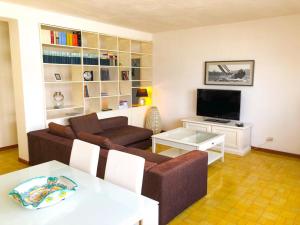 een woonkamer met een bank en een tv bij Romantica Bocca di Magra in Bocca di Magra