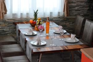 a table with plates and wine glasses on it at Apartment Blue Paradise in Preko