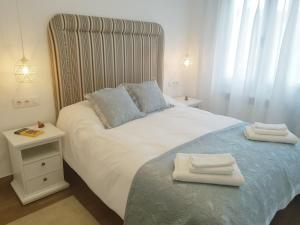 a bedroom with a large bed with two towels on it at Fuente Foncalada Oviedo Centro Gascona in Oviedo