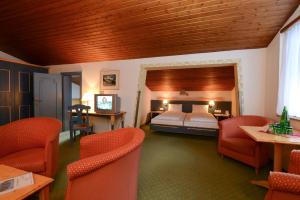 a bedroom with a bed and chairs in a room at Sporthotel Heiligenblut in Heiligenblut +52 photos