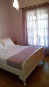 Un dormitorio con una cama grande con ventana. en Sea Whispers Beach House, en Alykes