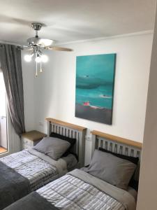 Un dormitorio con dos camas y un cuadro en la pared. en Casa Emperador Penthouse, en Roldán 33 fotos más