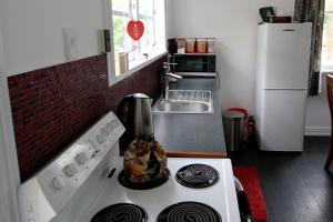 eine Küche mit einem Herd Top-Backofen neben einem Kühlschrank in der Unterkunft Whanga Bridge House in Whangamomona
