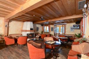 a living room with tables and chairs and a fireplace at Sporthotel Heiligenblut in Heiligenblut