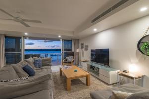 a living room with a couch and a tv at Anchorage - Riverfront Luxury on Gympie Terrace in Noosaville