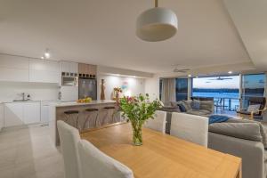 a kitchen and living room with a table and chairs at Anchorage - Riverfront Luxury on Gympie Terrace in Noosaville