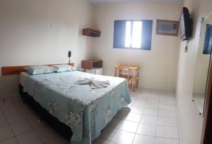 1 dormitorio con 1 cama y TV en Hotel Águia, en Teixeira de Freitas