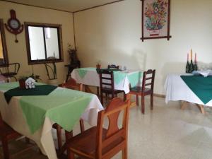 a dining room with two tables with green and white tablecloths at Monte Los Lirios Lodge in Monteverde Costa Rica