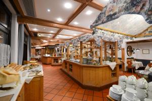 a restaurant with a counter with plates and dishes at Sporthotel Heiligenblut in Heiligenblut